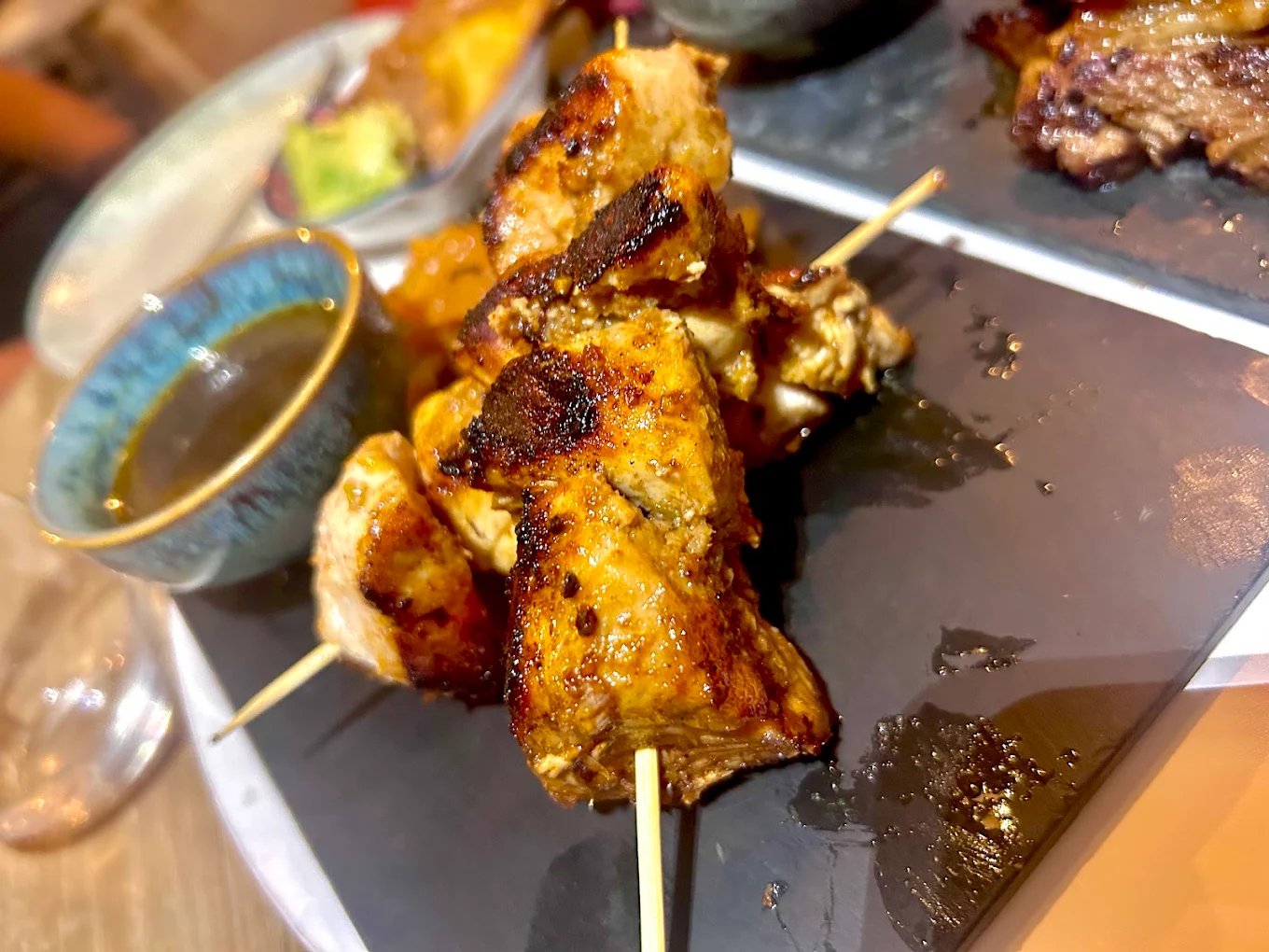 Brochettes grillées servies sur ardoise avec une sauce